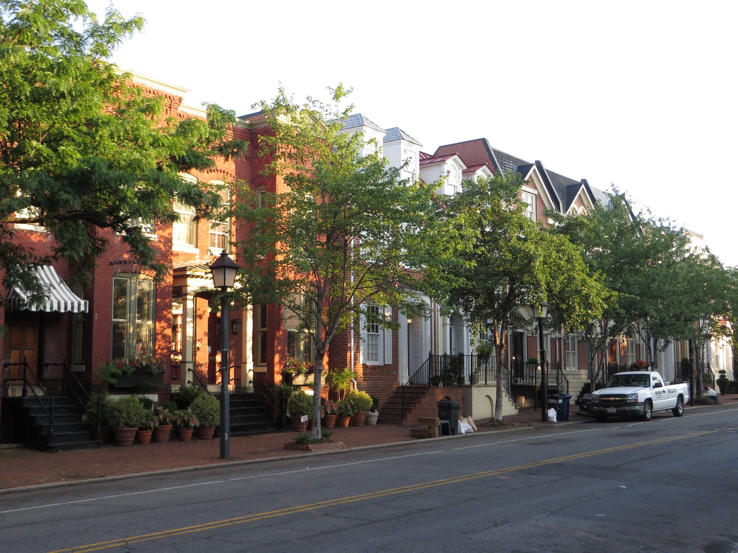 A tree-lined street of brick townhouses in Old Town Alexandria, Virginia