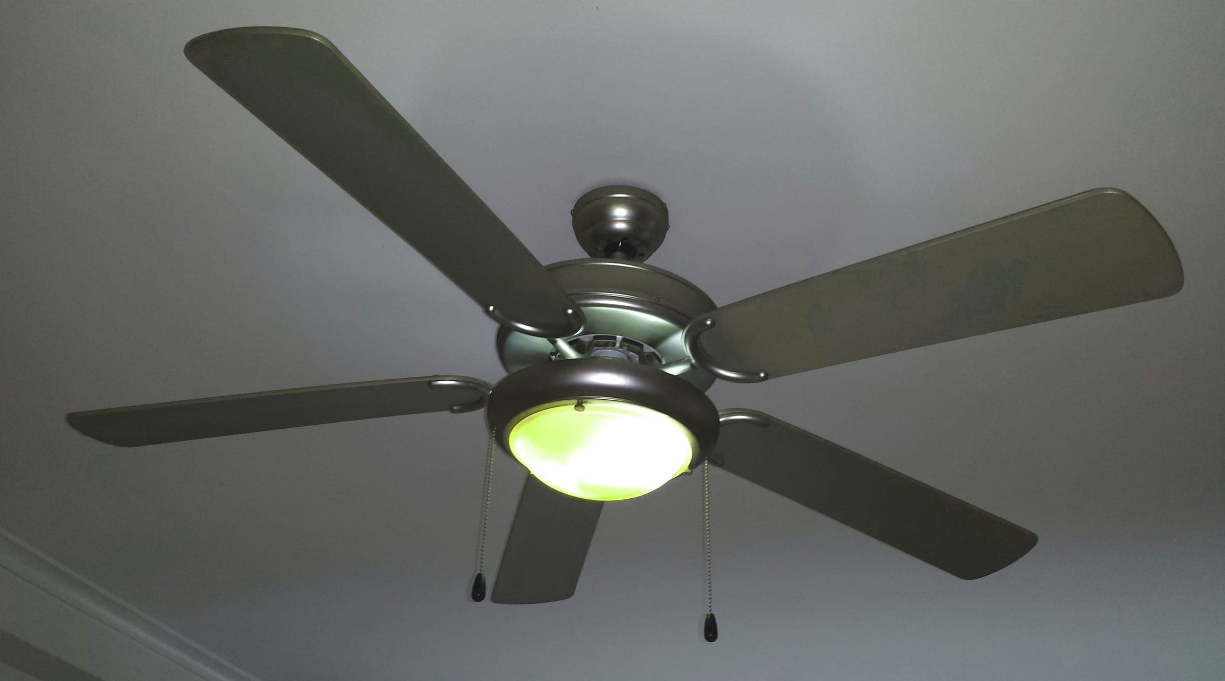 A ceiling fan with a light fixture mounted on a white ceiling